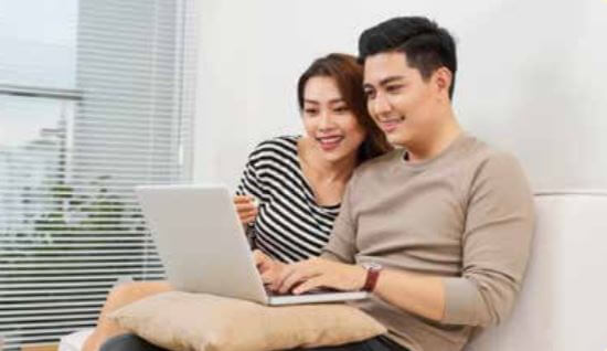 Couple researching homes on a a computer